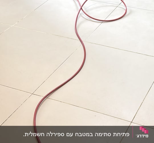 פתיחת סתימה בצנרת המטבח מתחת לכיור באמצעות קפיץ אינסטלציה